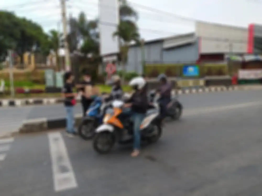 Bagi-bagi takjil buat pengendara motor.