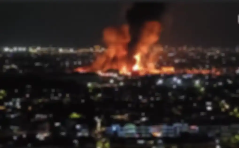 Api besar membumbung tinggi ke langit dalam gelap malam. Korban jiwa berjatuhan akibat kekabaran Depo Pertamina Plumpang.