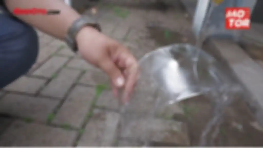 Bilas visor helm dengan air mengalir.