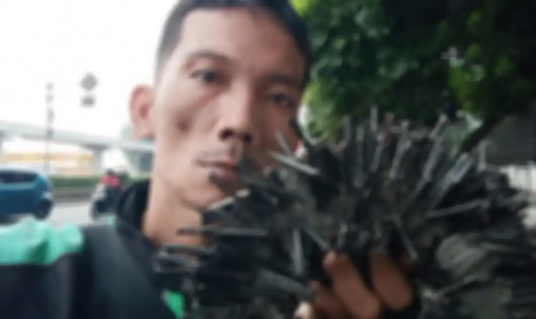 Uum Hidayat mengumpulkan ranjau paku disela-sela pekerjaannya sebagai driver ojol.