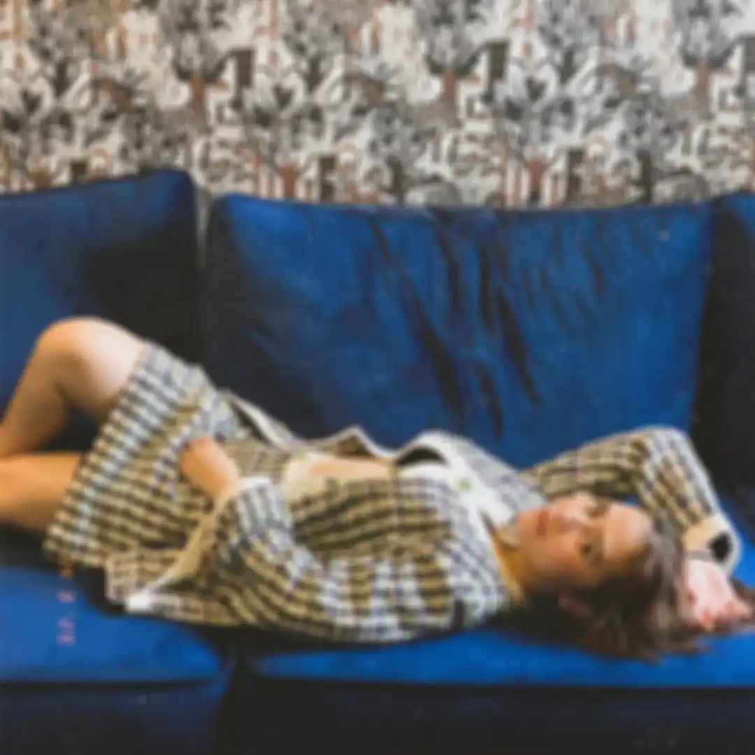 Penampilan modis Prilly saat foto sambil rebahan di sofa
