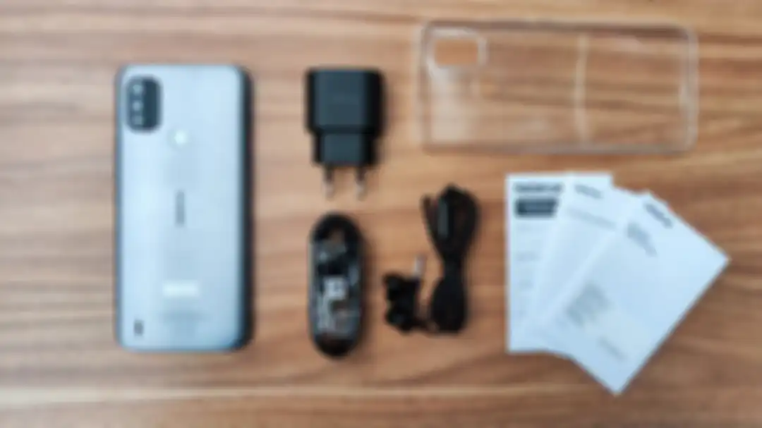 Isi kotak pembelian Nokia C21 Plus yang masih mentediakan adapter charger dan earphone. 