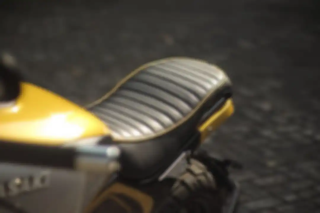 Modifikasi Kawasaki ER-6n scrambler, jok dengan kulit sintetis hitam beludru motif horizontal serta list aksen kuning
