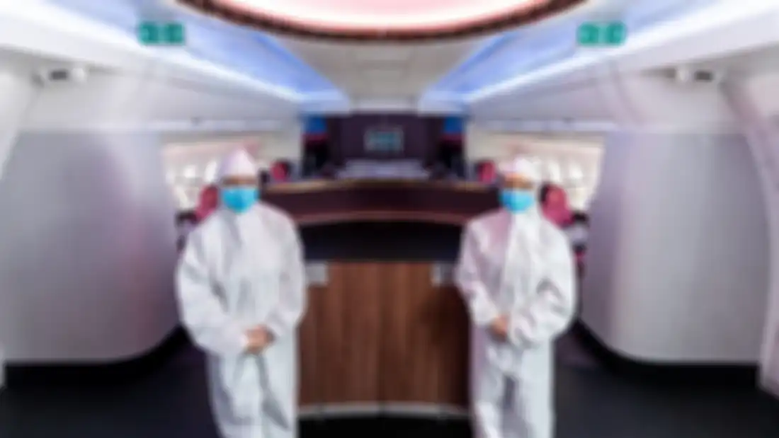 Pramugari Qatar Airways kenakan hazmat suite.
