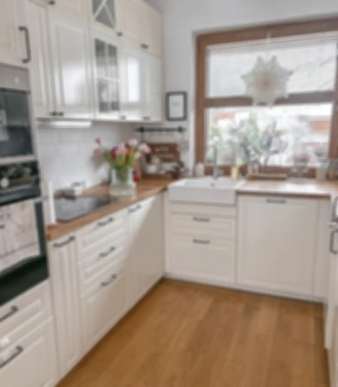 Penggunaan kayu membuat desain dapur warna putih terasa semakin hangat.
