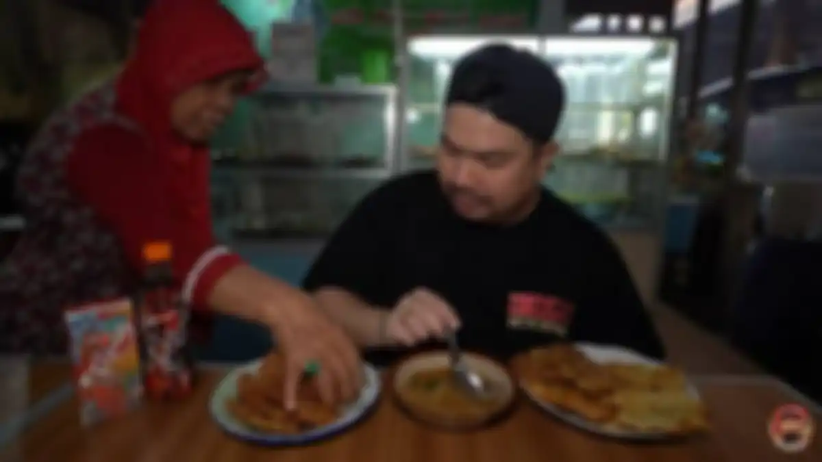 Ibu-ibu mengambil gorengan di meja Nex Carlos saat syuting konten