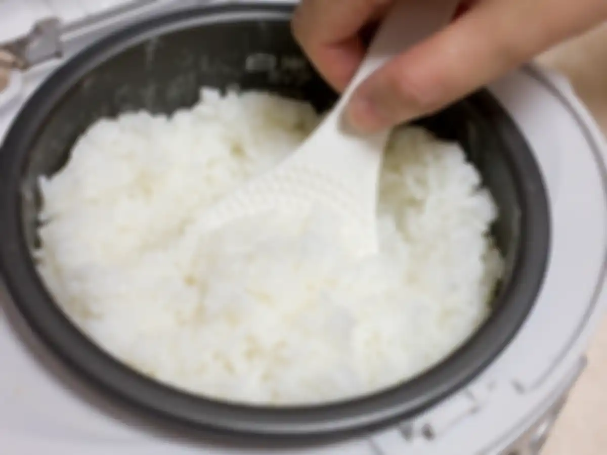 Memasak nasi dengan rice cooker atau magic com.