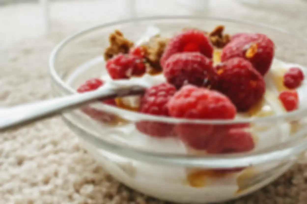 Ilustrasi yogurt yang disajikan dengan topping buah, madu, dan granola