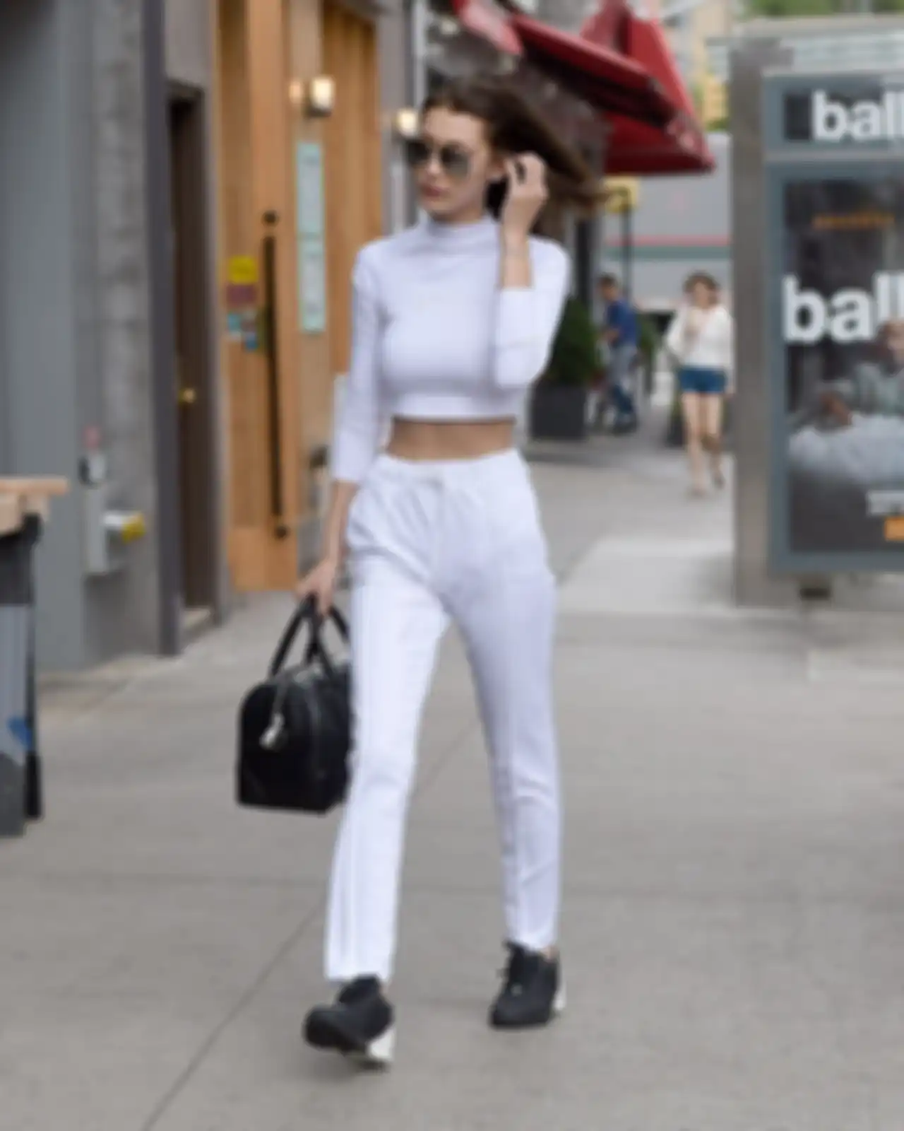 Bella Hadid memakai turtleneck crop top dan sweatpants