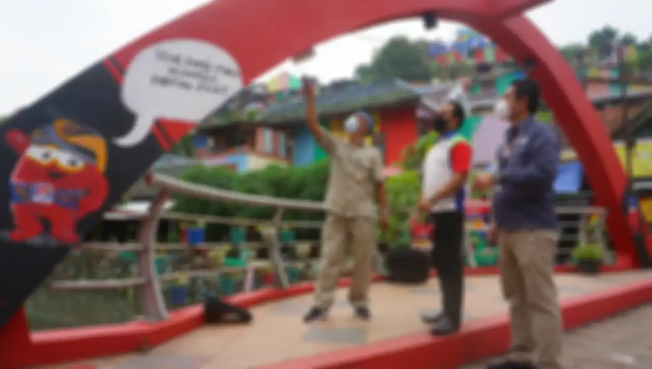 Marselino Najoan (tengah) dan HS Handoyo (kanan) di jembatan Kampung Pelangi.