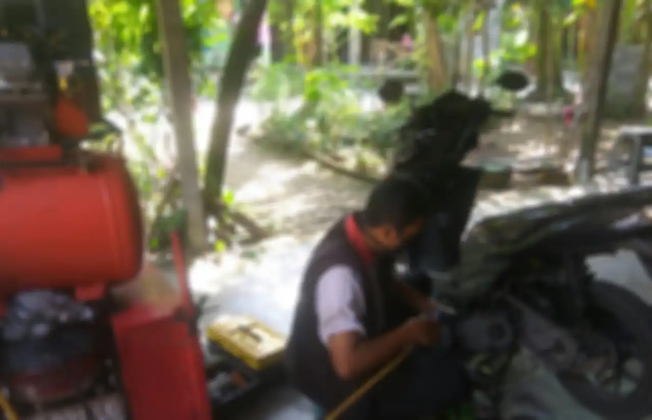 Novianto mekanik motor panggilan asal Sleman menggunakan mesin impact dan kompresor saat service di rumah konsumen