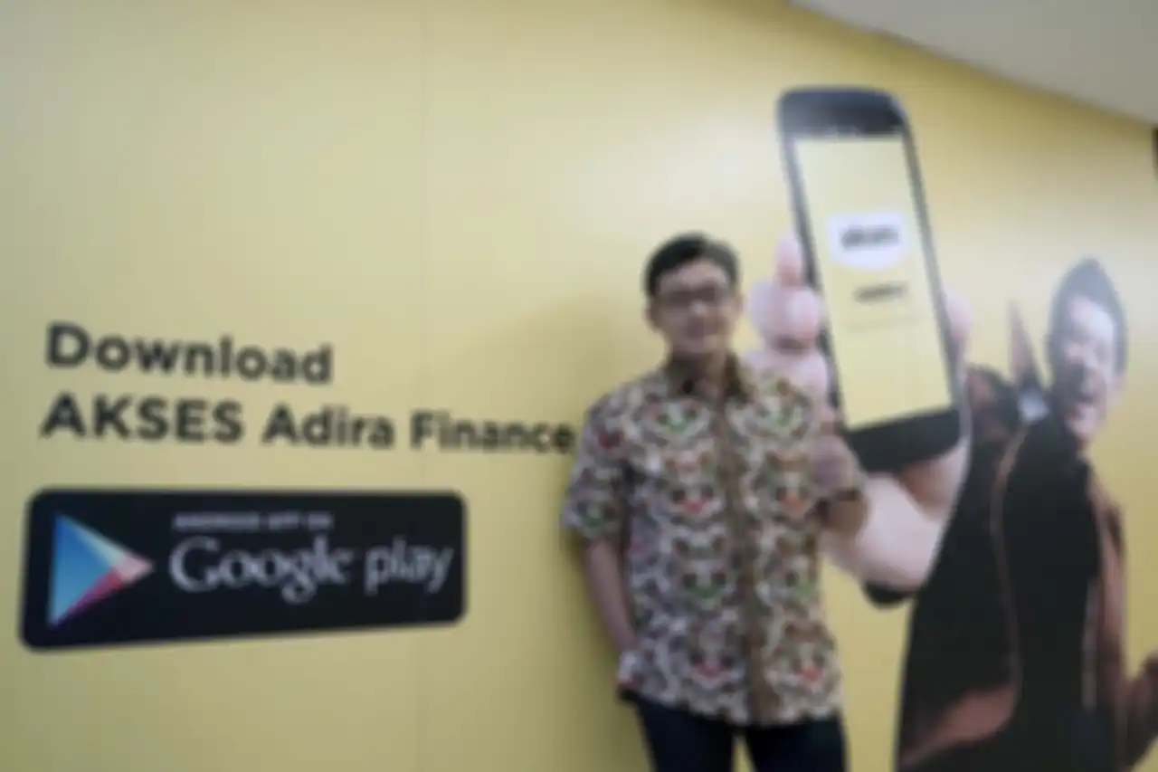 Niko Kurniawan berpose dengan gambar iklan Adira Finance Akses.