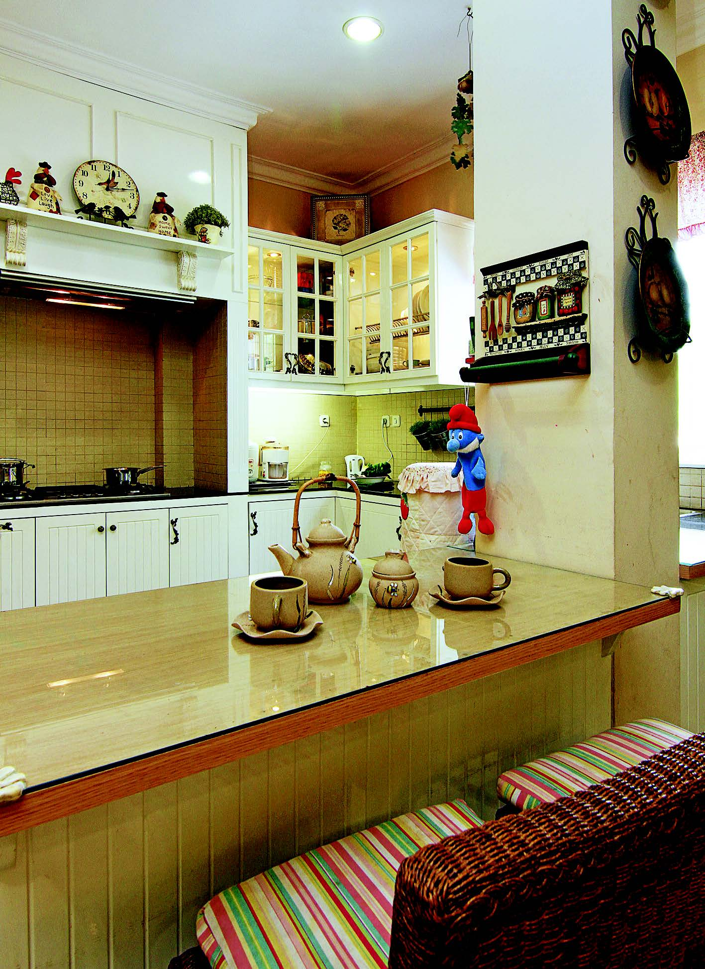 Pada tabletop, granit hitam lapisi area persiapan dan saji di dapur american country.
