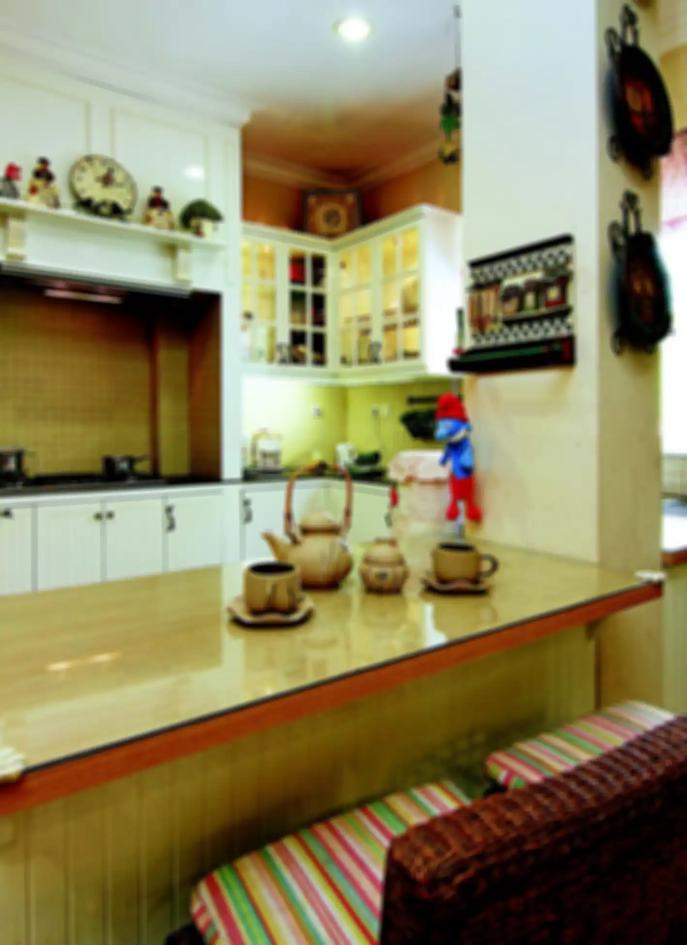 Pada tabletop, granit hitam lapisi area persiapan dan saji di dapur american country.