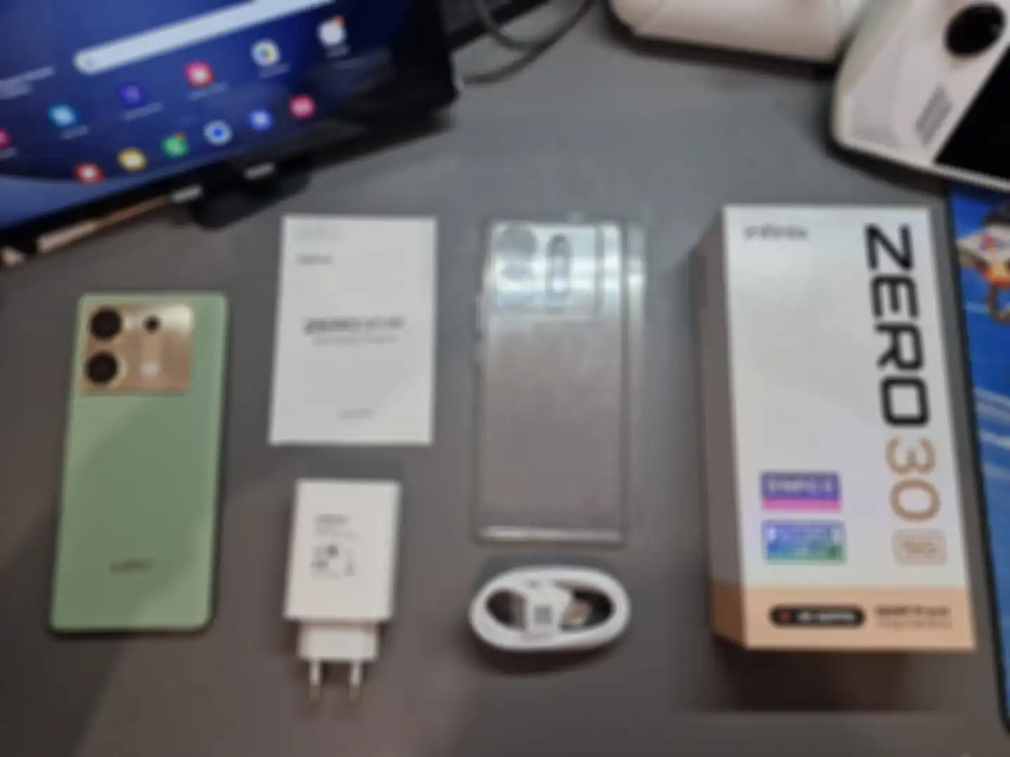 Isi kotak dari Infinix Zero 30 5G yang berisi unit HP, charger, kertas panduan, garansi, casing, kabel, dan anti gores