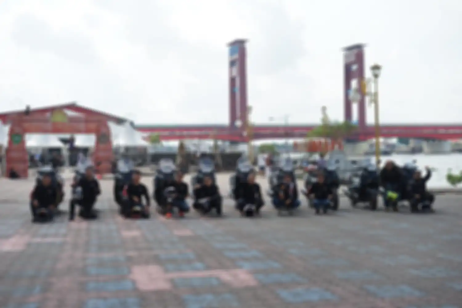 Para komunitas dan media berfoto dengan Yamaha XMAX Connected dan berlatar belakang Jembatan Ampera.