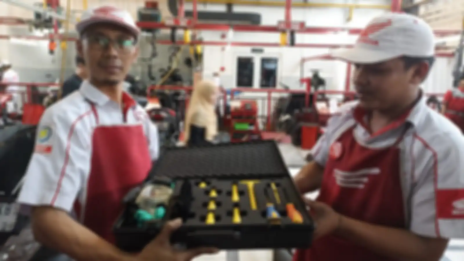 Mekanik Motor Listrik Honda dengan badge gambar petir pada lengan kanannya. 
