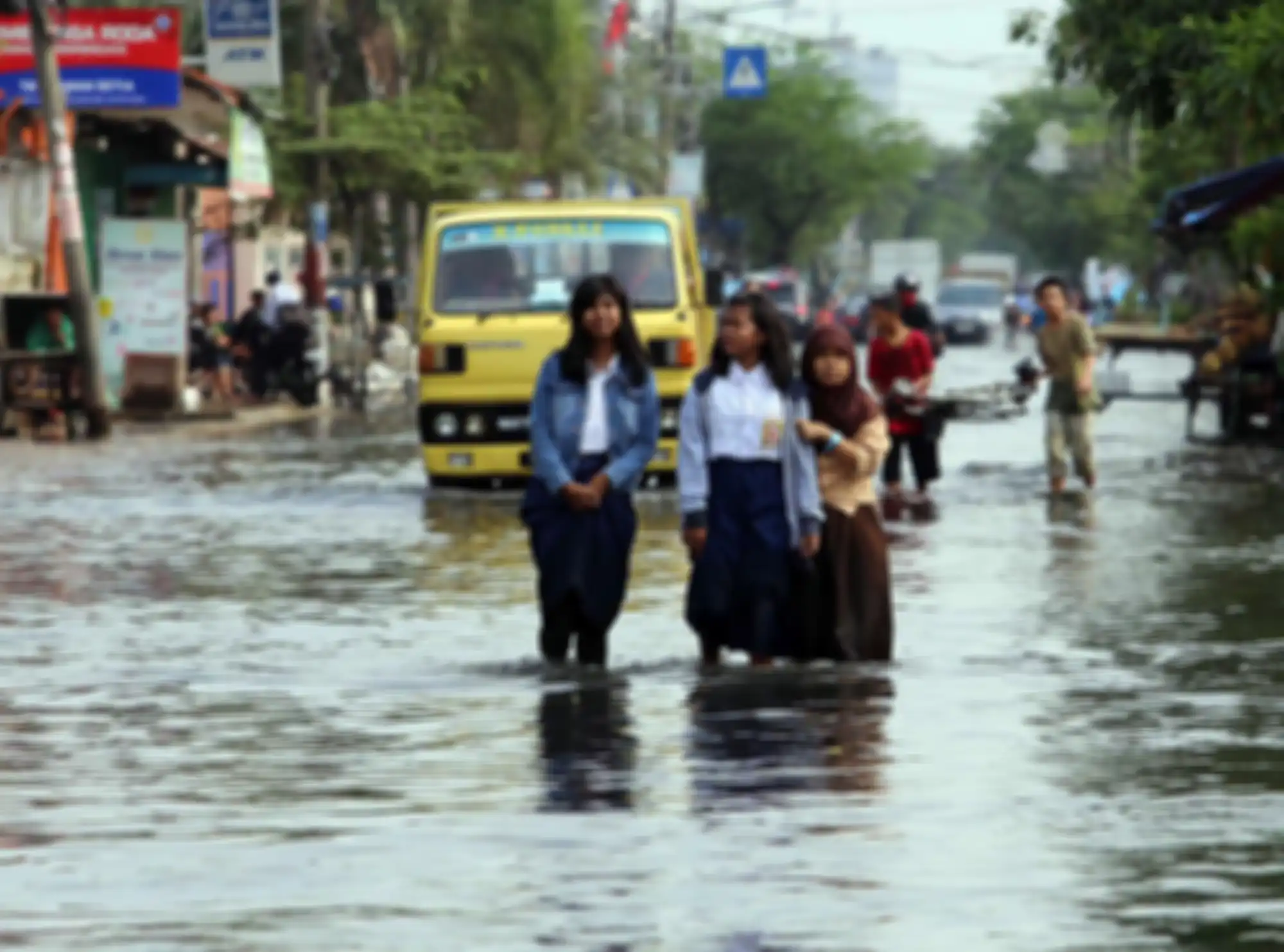 Siswa sekolah melintasi banjir yang menggenangi Jalan Kramat Jaya, Semper Barat, Jakarta Utara, Rabu (12/3/2014). Setiap kali hujan lebat mengguyur kawasan itu, jalan tersebut selalu banjir. Hal itu diperparah oleh sistem drainase yang buruk. Warta Kota/angga bhagya nugraha