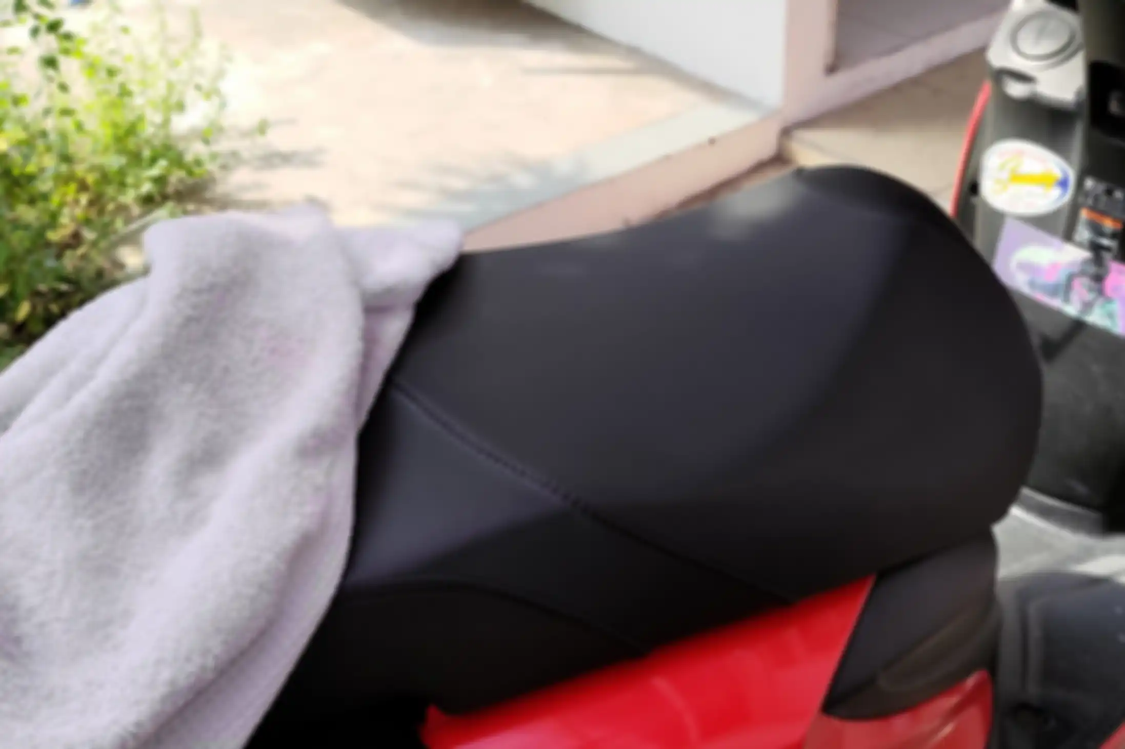 Menggelar handuk di atas jok motor menjadi salah satu cara mencegah jok motor rusak dicakar kucing.