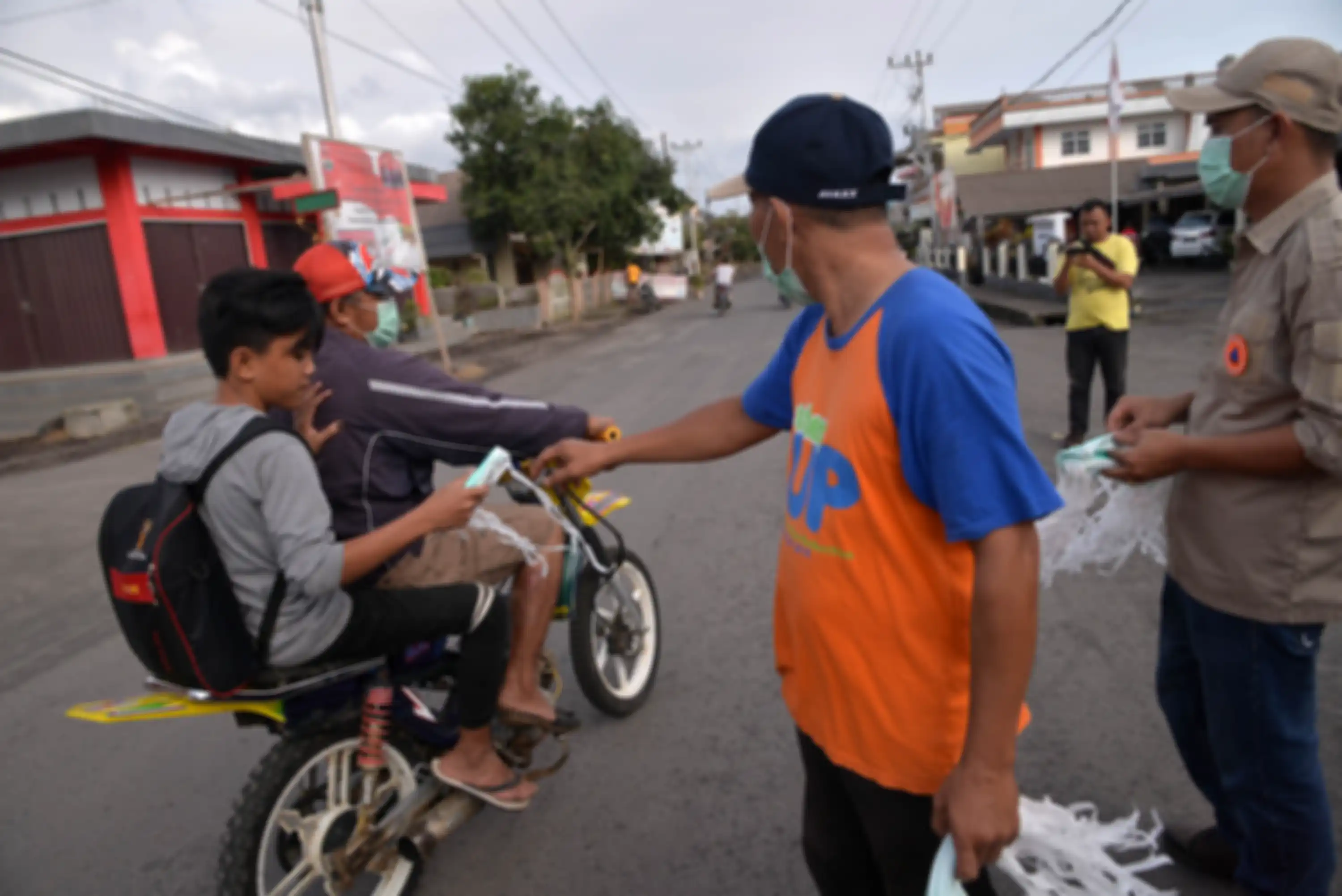 Personel Kepolisian bersama anggota BPBD Sulut membagikan masker kepada pengendara dan pejalan kaki 