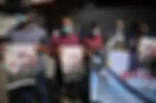 Para pengunjuk rasa memegang foto-foto tahanan Palestina yang melakukan mogok makan, Maher al-Akhras selama unjuk rasa untuk menunjukkan solidaritas di Gaza.