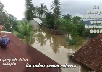 Meratapi Nasib Jadi Korban Banjir, Seorang Pemuda Nyanyi di Genteng Rumah