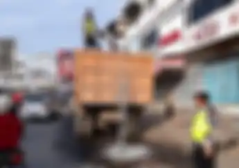 Keren Pak Polisi, Bantu Menutup Lubang Jalan Raya Supaya Enggak Bahaya