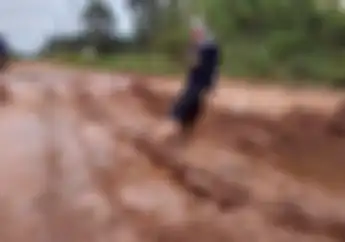 Sebagai Aksi Protes, Model Wanita Mandi Lumpur di Jalan yang Rusak