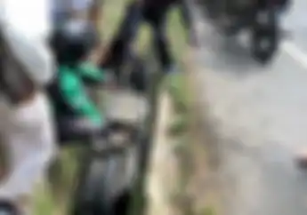 Mirip Film Komedi, Cewek Dan Motornya Terjungkal Ke Selokan Saat Pacarnya Ambil Topi Yang Jatuh