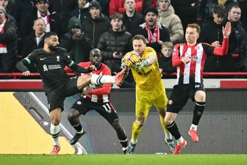 Mohamed Salah (kiri) berusaha merebut bola dari kiper lawan dalam laga Liga Inggris antara Brentford vs Liverpool di Gtech Community Stadium (18/1/2025).