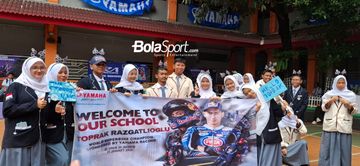 Pelajar SMKN 39 Jakarta memegang spanduk menyambut kedatangan Pembalap Pramac Yamaha, Toprak Razgatlıoğlu, dalam acara meet and greet di SMKN 39 Jakarta, Selasa (20/1/2026).