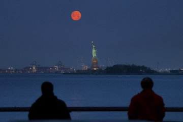 Foto menakjubkan menunjukkan Super Blood Moon raksasa bersinar di atas Kota New York Amerika Serikat.