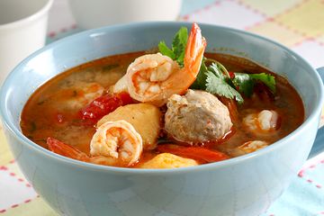 Semangkuk bakso kuah pedas dengan kuah merah menggoda, lengkap dengan tahu goreng