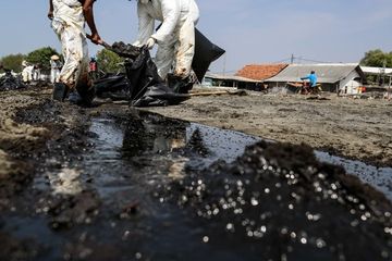 Warga mengumpulkan limbah tumpahan minyak Oil Spill yang tercecer milik Pertamina di Pesisir Pantai Cemarajaya, Karawang, Jawa Barat, Minggu (4/8/2019). Pasir yang tercemar minyak tersebut dikumpulkan dan akan dipindahkan ke pabrik penyimpanan limbah B3 (Bahan Berbahaya dan Beracun) untuk dimusnahkan.