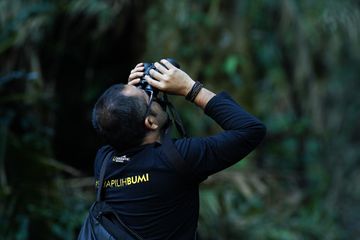 Didi Kaspi Kasim, Editor in Chief National Geographic Indonesia, tengah memata-matai owa jawa. Primata yang berhabitat di TNGGS ini kerap dijuluki pesinden rimba karena nyayiannya.