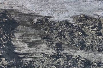 Foto ini menunjukan bagian es yang berwarna coklat yang menjadi bukti pernah adanya lalu lintas yang menggunakan kuda melewati jalur vital Norwegia era Viking ini.
