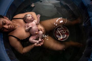Lelah setelah melahirkan putrinya, Suzette, Kim Bonsignore berbaring di kolam bersalin di ruang tamunya. Alih-alih memiliki bayinya di rumah sakit seperti yang direncanakan, Bonsignores memutuskan untuk memiliki anak kedua mereka di rumah karena pandemi coronavirus.
