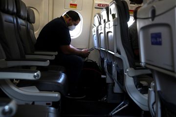 Seorang penumpang di dalam pesawat United Airlines yang tidak berbayar menunggu untuk berangkat dari Bandara George Bush Intercontinental di Houston, Texas pada 11 Mei 2020.