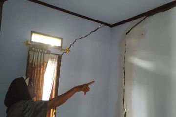 Warga menunjuk retakan pada dinding rumah dampak bencana tanah bergerak di Kampung Ciherang, Desa Cijangkar, Kecamatan Nyalindung, Sukabumi, Jawa Barat, Minggu (3/1/2021).