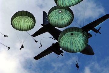 Penerjunan militer dari pesawat  Hercules dengan parasut tipe T-10D. 