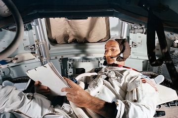 Michael Collins di dalam misi Apollo 11 sedang membaca modul komando.