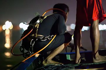 Seorang nelayan bersiap untuk menyelam bebas dengan sistem pernapasan dan rantai besi untuk sabuk pemberat, di Sungai Musi di Palembang dalam misi mencari harta karun yang tenggelam.