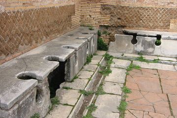 Jamban Romawi kuno di Ostia Antica, sebuah situs arkeologi di barat daya Roma.