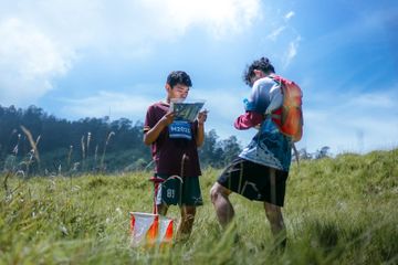 Peserta lomba Orienteering Race 2023 menggunakan alat navigasi di padang rumput Gunung Pangonan, Dieng. Lomba ini bertujuan untuk memperkenalkan berbagai wisata di Dieng yang digelar selama dua hari.