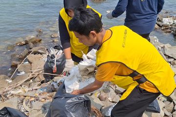 Seorang warga mengumpulkan sampah di kawasan pesisir Desa Ketapang, Mauk, Kabupaten Tangerang.