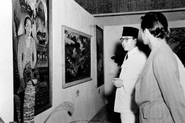 Presiden Soekarno pada suatu kunjungan pameran lukisan di Jakarta, mengamati lukisan 'Sumilah' karya
