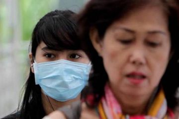 Warga menggunakan masker ketika beraktivitas di sekitar Bundaran Hotel Indonesia, Jakarta Pusat.