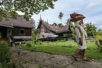 Seorang ibu warga kampung Koto Padang Ranah membawa jamba atau makanan dengan dijunjung di atas kepala.