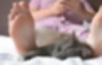5 Alasan Kucing Suka Tidur di Kaki Pemiliknya. Tanda Sayang?