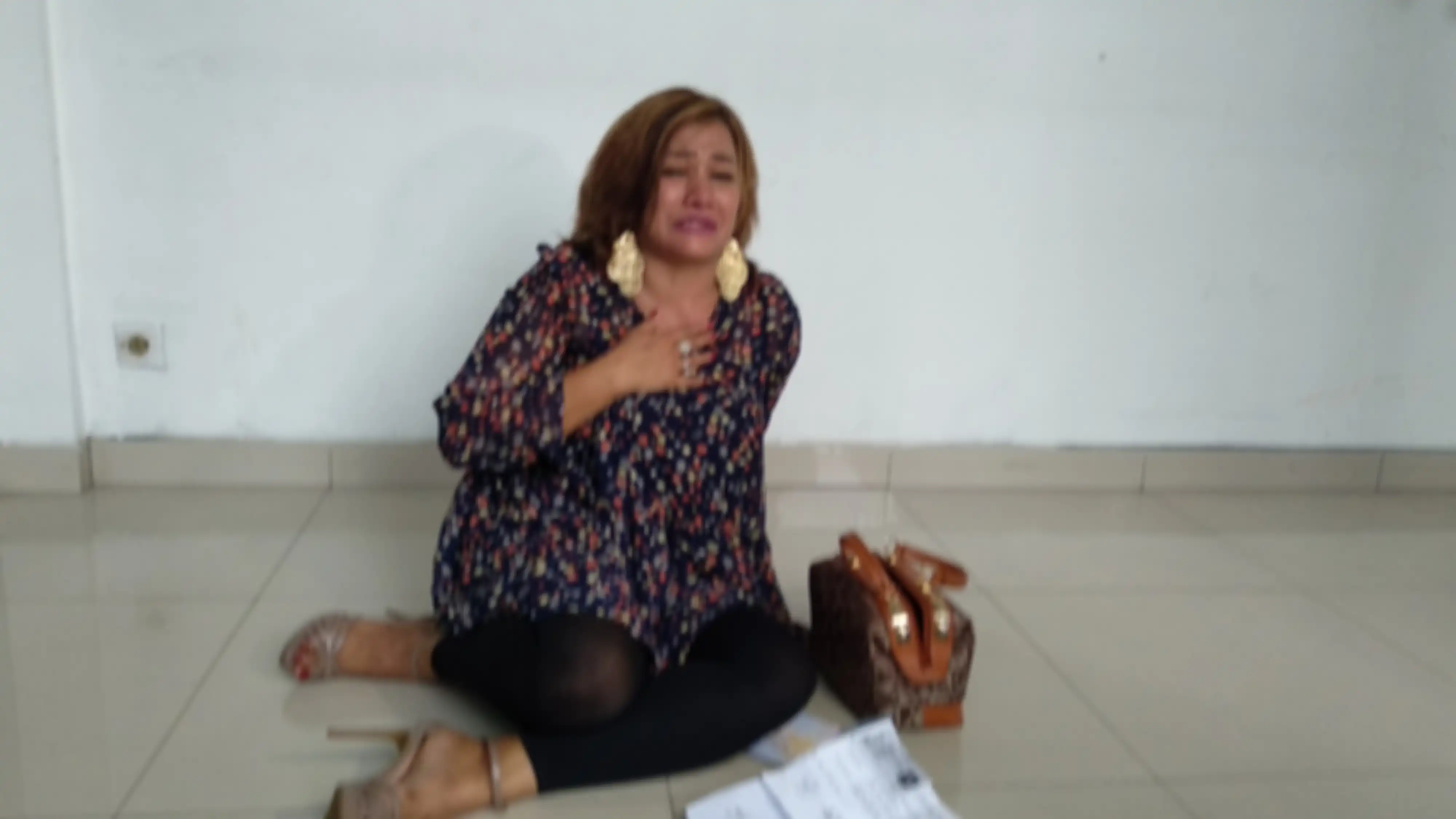 Mega Makcik terjatuh ke lantai di teras Pengadilan Negeri Jakarta Timur pada Rabu (24/4/2019)